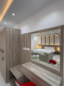 a bedroom with a bed and a mirror at مؤسسة مطلة الورد Matallat Alward Est in Taif
