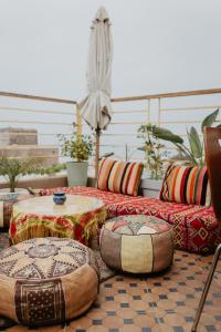 un patio con un tavolo e alcuni cuscini e tavoli di Anza Surf Experience Hostel ad Agadir
