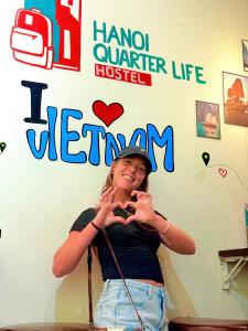 a woman is standing in front of a wall at Hanoi Quarter Life Hostel in Hanoi +41 photos