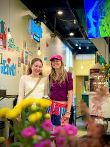 two women standing next to each other in a store at Hanoi Quarter Life Hostel in Hanoi