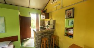 a room with a kitchen with a fireplace and a bedroom at Merlin Guest House in Rodrigues Island +23 photos