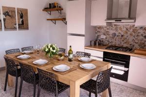 a dining room table with chairs and a kitchen at 2ª Casa del Borgo Antico in Poggibonsi
