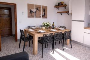 a dining room with a wooden table and chairs at 2ª Casa del Borgo Antico in Poggibonsi +5 photos