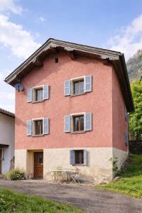 a red brick house with windows and a table at Waterfall House - Art and Design, Ski, Hike, Swim in Mesocco