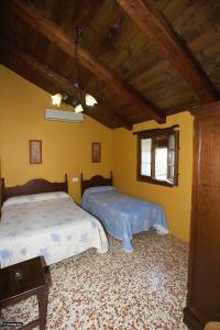 a bedroom with two beds and a ceiling at Casa del Huerto in El Bosque