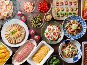 a table full of different types of food on plates at ibis Styles Kyoto Shijo in Kyoto
