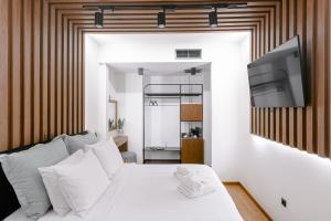 a bedroom with a white bed and a television at Mamy Blue Slow Living in Athens