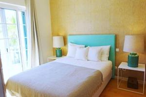 a bedroom with a large bed with two lamps and a window at Formosa Villas in Quinta do Lago