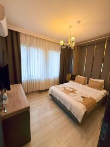 a bedroom with a large bed and a chandelier at New Taksim Hotel in Istanbul