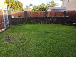 a backyard with a fence and green grass at Appartement 974 in Le Tampon