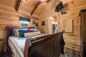 a bedroom with a bed in a wooden cabin at Smoky Mountain Mist, Tiny House, Custom Log Cabin in Bryson City