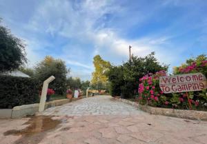 a sign that says welcome to gardening and flowers at Garden Lake Camping in Ksamil +89 photos