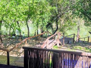 a wooden bridge with a wooden fence and trees at Bloemhof Riverside Chalets in Bloemhof
