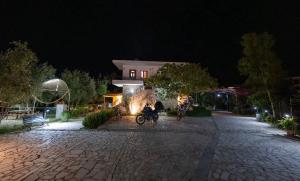 two motorcycles parked in front of a building at night at Garden Lake Camping in Ksamil