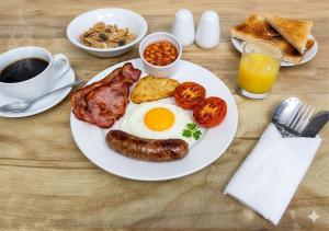 a plate of breakfast food with eggs bacon tomatoes and toast at Trevellis Bed and Breakfast in Newquay