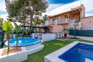 a backyard with a swimming pool and a house at Villa Salvaje Beach in San Francesch