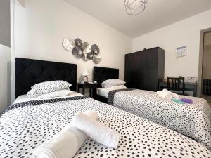 a bedroom with two beds and a clock on the wall at Albert's apartment Center 101 in Larnaca