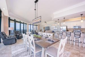 a dining room and living room with a table and chairs at The Oasis 411 formerly Phoenix West II 411 in Orange Beach
