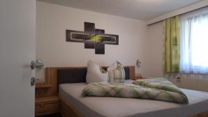 a bedroom with a bed with a cross on the wall at Landhaus Zangerl - Kobelerhof in Landeck +28 photos