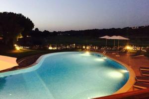 a large blue swimming pool with chairs and umbrellas at Formosa Villas in Quinta do Lago