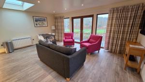 a living room with a couch and two chairs and a table at Bunroy Park in Fort William