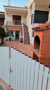 a white fence in front of a house with a patio at Apartalux Benicassim Premium in Benicàssim +15 photos