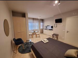 a bedroom with a bed and a table and a kitchen at HB Appartamenti in centro Bergamo in Bergamo