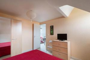 a bedroom with a bed and a tv on a dresser at Villa MERYEM in Néris-les-Bains