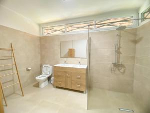 a bathroom with a toilet and a sink and a shower at Hasoa Villa in Morondava +14 photos