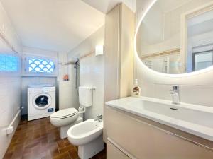 a bathroom with a toilet sink and a washing machine at VILLA TRAMONTO in Levanto +25 photos