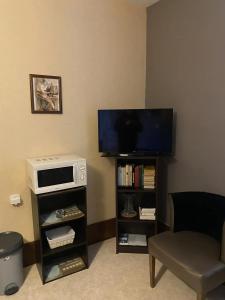 a living room with a tv and a microwave at Villa MERYEM in Néris-les-Bains