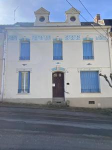 a white building with blue windows and a door at Villa MERYEM in Néris-les-Bains