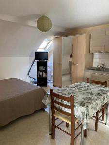 a room with a bed and a table and a kitchen at Villa MERYEM in Néris-les-Bains