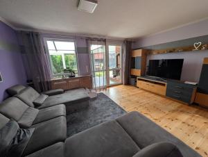 a living room with a couch and a flat screen tv at Familiengeeignete Ferienwohnung in Königs Wusterhausen