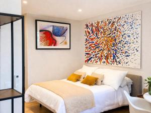 a bedroom with a bed with a large painting on the wall at Alta Luminara Boutique Residence Sea View Terraces Marbella Hills in Benahavís