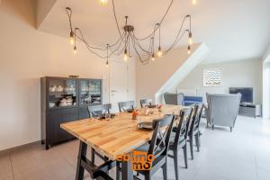 a dining room with a wooden table and chairs at Zee en Polder 134 in Middelkerke +15 photos