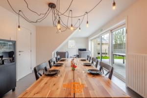 a dining room with a long wooden table and chairs at Zee en Polder 134 in Middelkerke