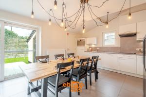 a kitchen and dining room with a wooden table and chairs at Zee en Polder 134 in Middelkerke