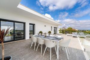 a dining room with a table and chairs on a patio at Villa Adão Lobo in Cadaval