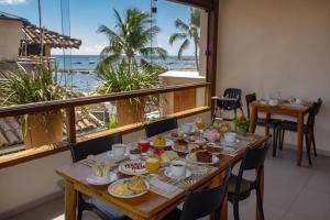 a table with food and a view of the ocean at Terra Bella Pousada in Morro de São Paulo