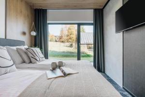 a bedroom with a bed with two books and a tv at Wierchy View - bespoke villas in Kościelisko