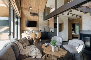 a living room with a couch and a table at Wierchy View - bespoke villas in Kościelisko