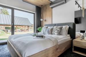 a bedroom with a large bed and a large window at Wierchy View - bespoke villas in Kościelisko +29 photos