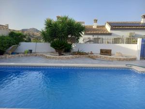 a large blue swimming pool in front of a house at Villa Sparrow, Arboleas in El Arroyo Aceituno