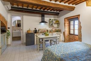 a kitchen with a bed and a table in a room at Pociano 1863 - Country House with Stunning view of Siena in Monteroni dʼArbia +40 photos