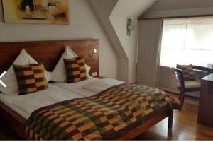 a bedroom with a bed with pillows and a window at Hotel Nassauer Hof in Kiedrich