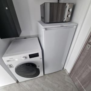 a washing machine with a microwave on top of it at Karlskovhuset in Give