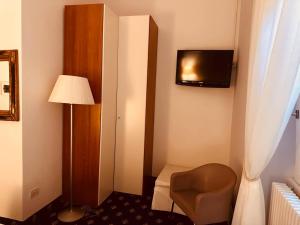 a hotel room with a chair and a television on the wall at My Hotel Milano in Milan