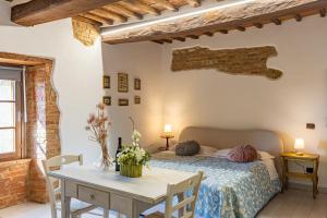 a bedroom with a bed and a table in a room at Pociano 1863 - Country House with Stunning view of Siena in Monteroni dʼArbia