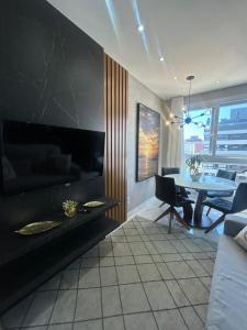 a living room with a table and a dining room at Loft sua morada in Capão da Canoa +11 photos